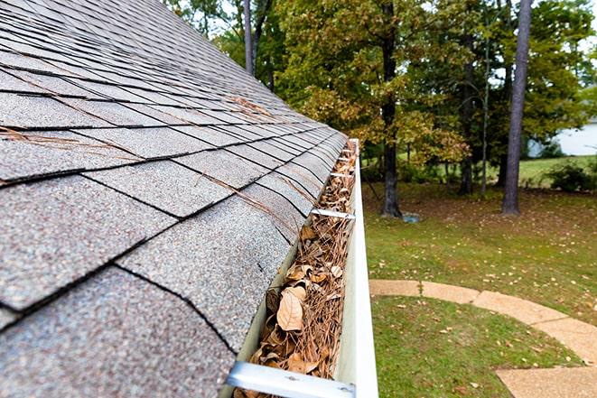 clearing out gutter for proper water drainage